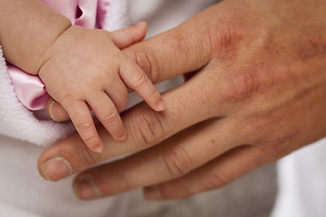 Image showing Baby Girl Hand Holding Rough Finger of Dad
