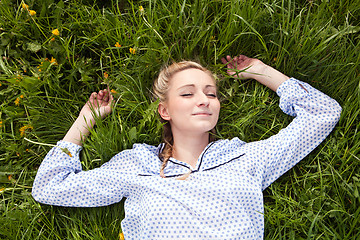 Image showing young woman lying in green gras happy