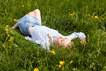 Image showing young woman lying in green gras happy