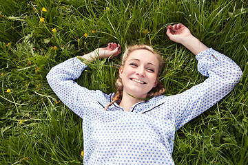 Image showing young woman lying in green gras happy