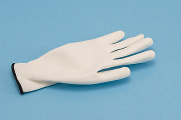 Image showing White working glove on blue background 