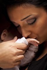 Image showing Ethnic Woman Kisses Her Newborn Baby Hand