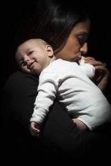 Image showing Ethnic Woman Kisses Her Newborn Baby Hand