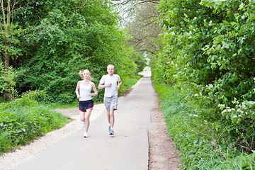 Image showing young couple is jogging in the forest