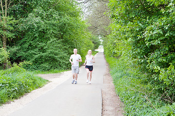 Image showing young couple is jogging in the forest