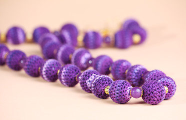 Image showing Violet beads at pink background