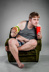 Image showing fat man eating hamburger