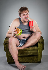 Image showing fat man eating hamburger