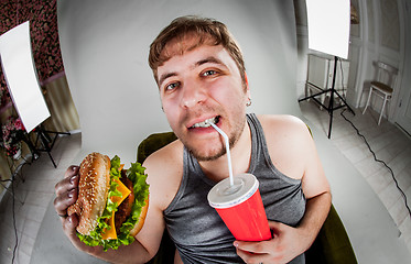 Image showing fat man eating hamburger