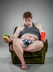 Image showing fat man eating hamburger