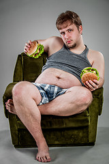 Image showing fat man eating hamburger