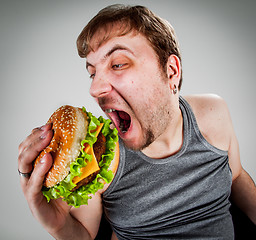 Image showing fat man eating hamburger