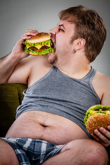 Image showing fat man eating hamburger