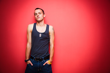 Image showing Young handsome man on red wall