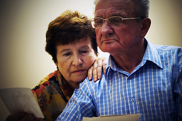 Image showing Senior couple looking at old photographs.