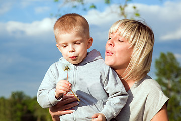 Image showing Kid and mother blowing dandelion