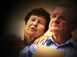 Image showing Senior couple looking at old photographs.