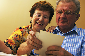 Image showing Senior couple looking at old photographs.