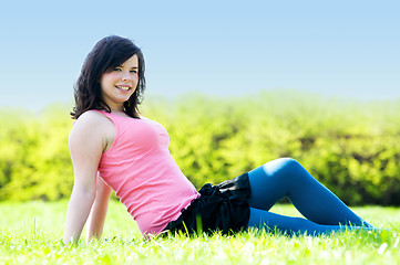 Image showing Young happy girl lying on grass