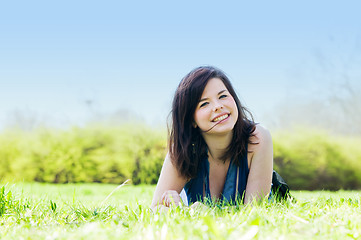 Image showing Young happy girl lying on grass