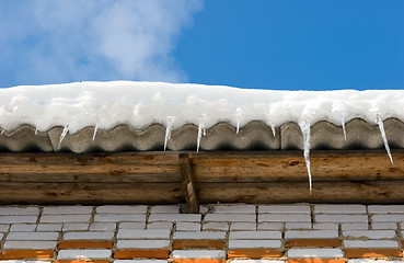 Image showing Snow covered roof with icicles