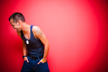 Image showing Young handsome man on red wall