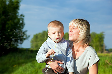 Image showing Kid and mother blowing dandelion