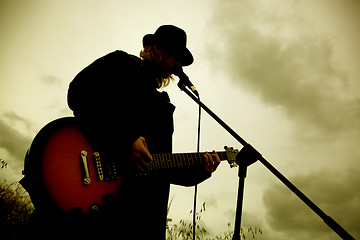 Image showing Man playing guitar outdoors