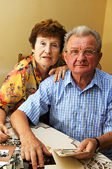 Image showing Senior couple looking at old photographs.