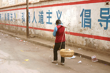 Image showing Woman transporting goods in China