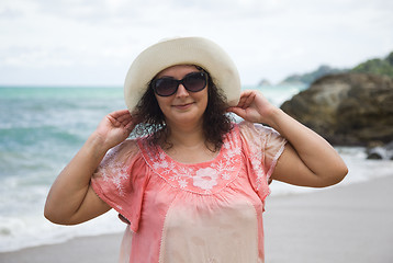 Image showing A woman in a white hat and sunglasses on the beach