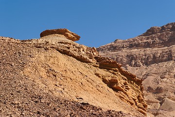 Image showing Weathered orange rock on top of dune in desert canyon