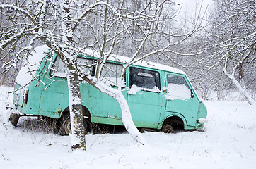 Image showing Old broken minibus covered with snow winter garden 