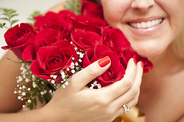 Image showing Smiling Woman Holding Bunch of Red Roses