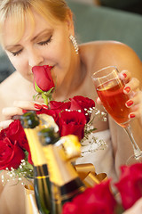 Image showing Blonde Woman Smells Roses at Mirror Near Champagne