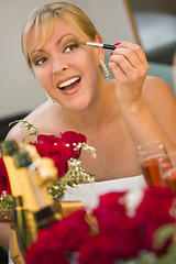 Image showing Blonde Woman Applies Makeup at Mirror Near Champagne and Roses