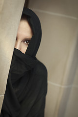 Image showing Cautious Islamic Woman in Window Pane Wearing Burqa or Niqab