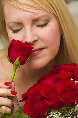 Image showing Woman Smelling a Bunch of Red Roses