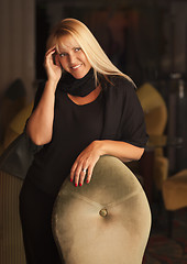 Image showing Beautiful Blonde Woman Standing Near Chair