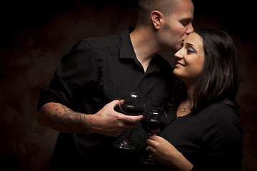 Image showing Happy Mixed Race Couple Flirting and Holding Wine Glasses