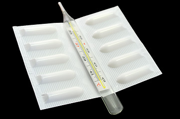 Image showing Medical suppository and thermometer on black background