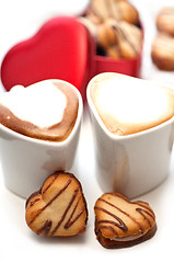 Image showing heart shaped cream cookies on red heart metal box and coffee