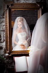 Image showing beautiful bride in white infront of mirror