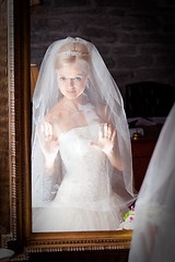 Image showing beautiful bride in white infront of mirror