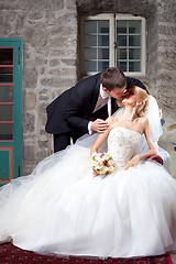 Image showing beautiful groom and bride kissing in old interior
