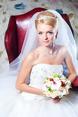 Image showing beautiful  bride sitting in red armchair