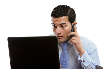 Image showing Man at computer making or receiving phone call