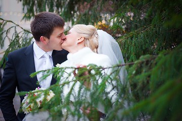 Image showing beautiful groom and the bride near a Christmas tree