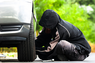 Image showing Young adult inspecting the wheel