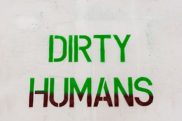 Image showing Dirty humans written on white wall